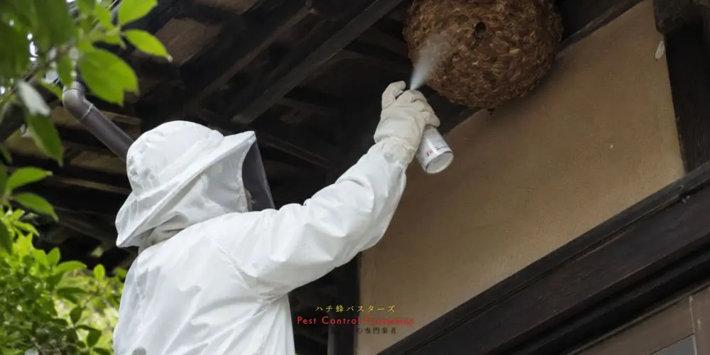 府中市の軒下にできた蜂の巣へ薬剤を散布する作業